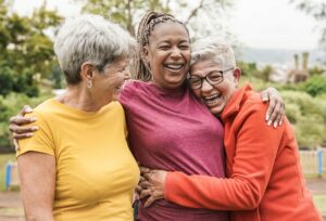 Happy multiracial senior women hugging