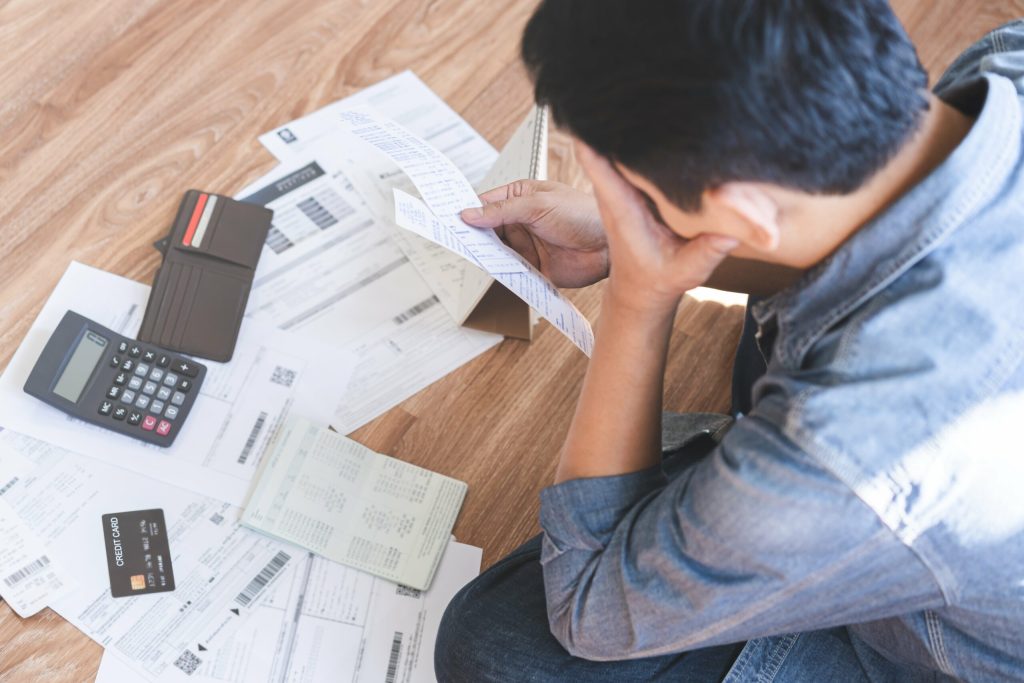 Overhead shot of man looking at his pile of bills