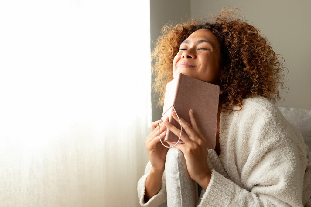 woman reading book in front of window