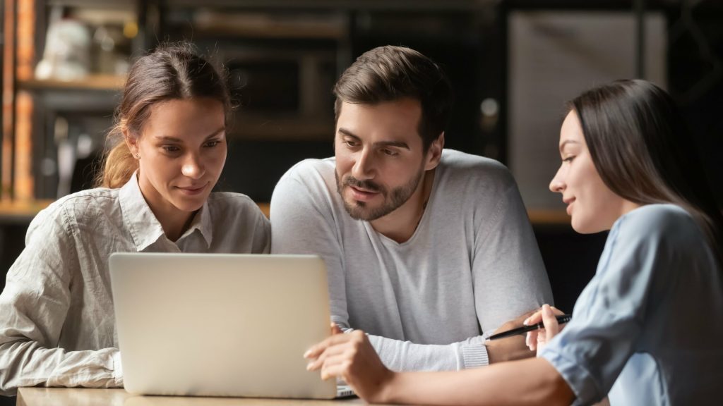 couple discussing finances together while looking over a computer