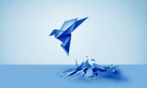 a blue paper origami bird emerging through a floor as a symbol of creativity