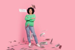 woman stands against pink background as money flies around her