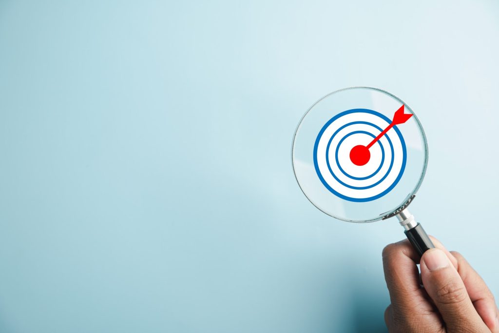 Magnifying glass being held up to a target.