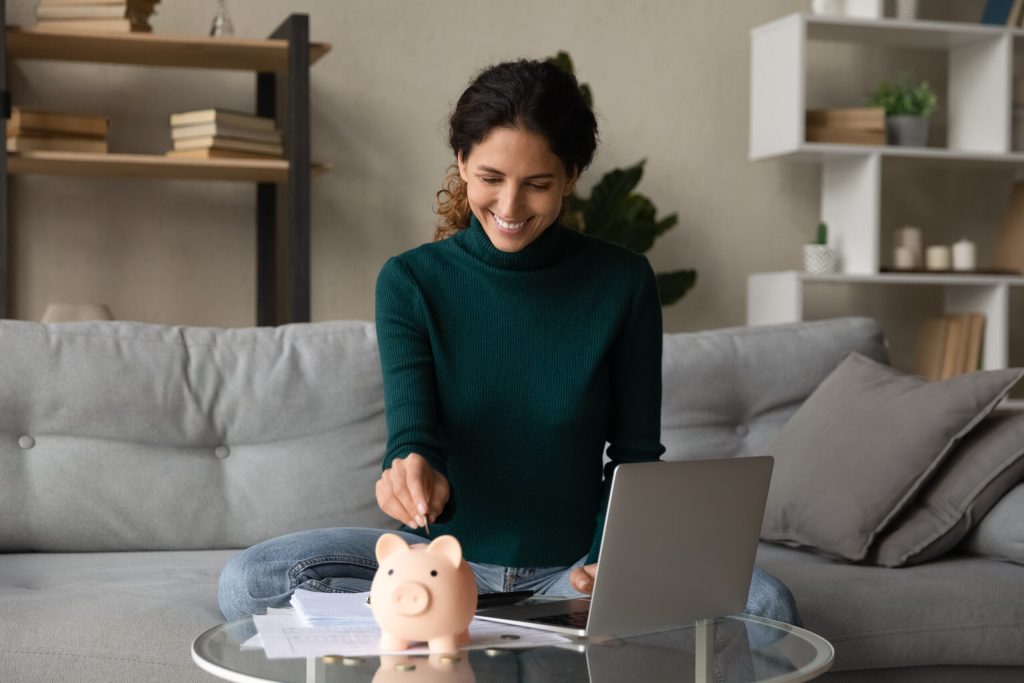 Woman putting money into a piggy bank