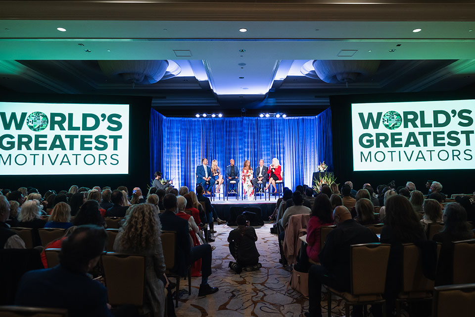 Audience listens to a panel with Sharon Lechter on stage at the World's Greatest Motivators event