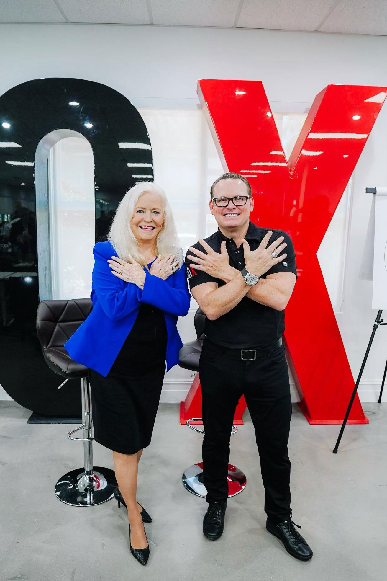 Sharon Lechter standing next to a man both with their arms crossed over their chest