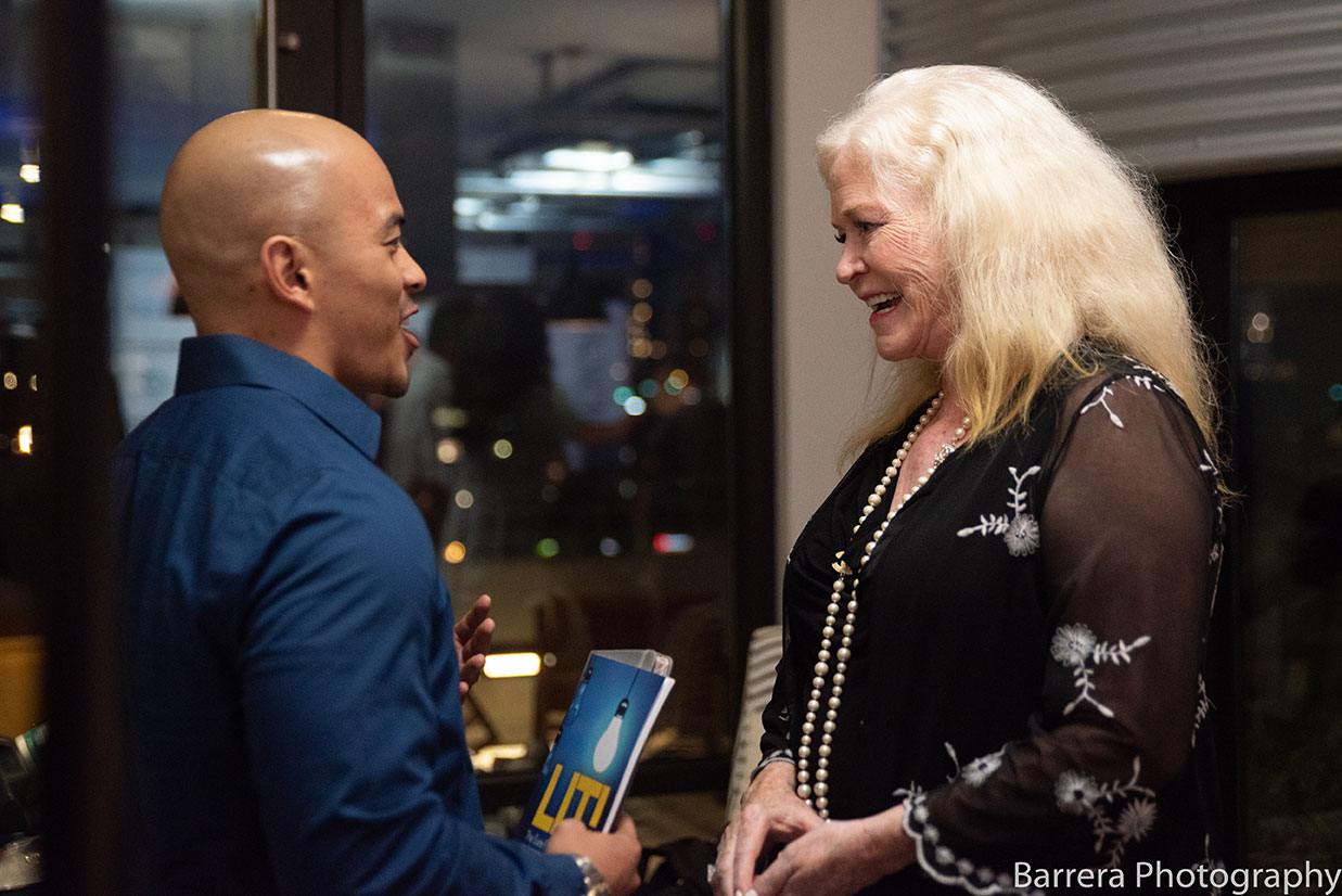 Sharon Lechter having a conversation with a man holding the book “LIT”