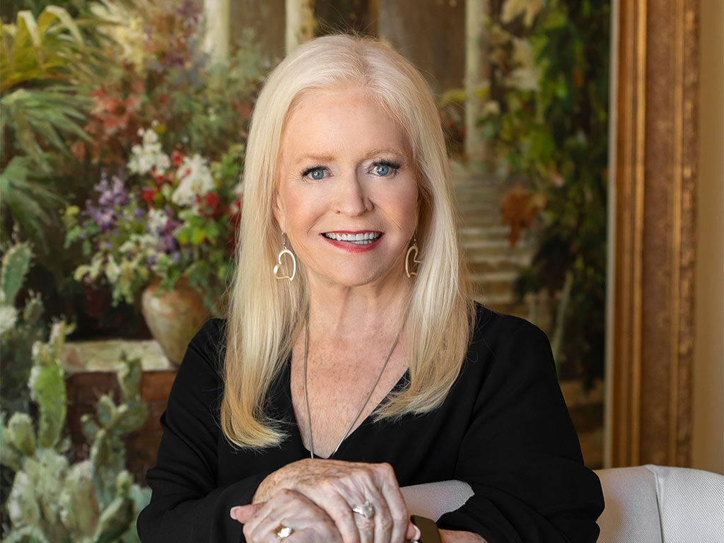 Sharon Lechter leaning on a chair