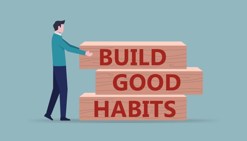 man stacking wooden blocks labeled "Build Good Habits" on a blue background