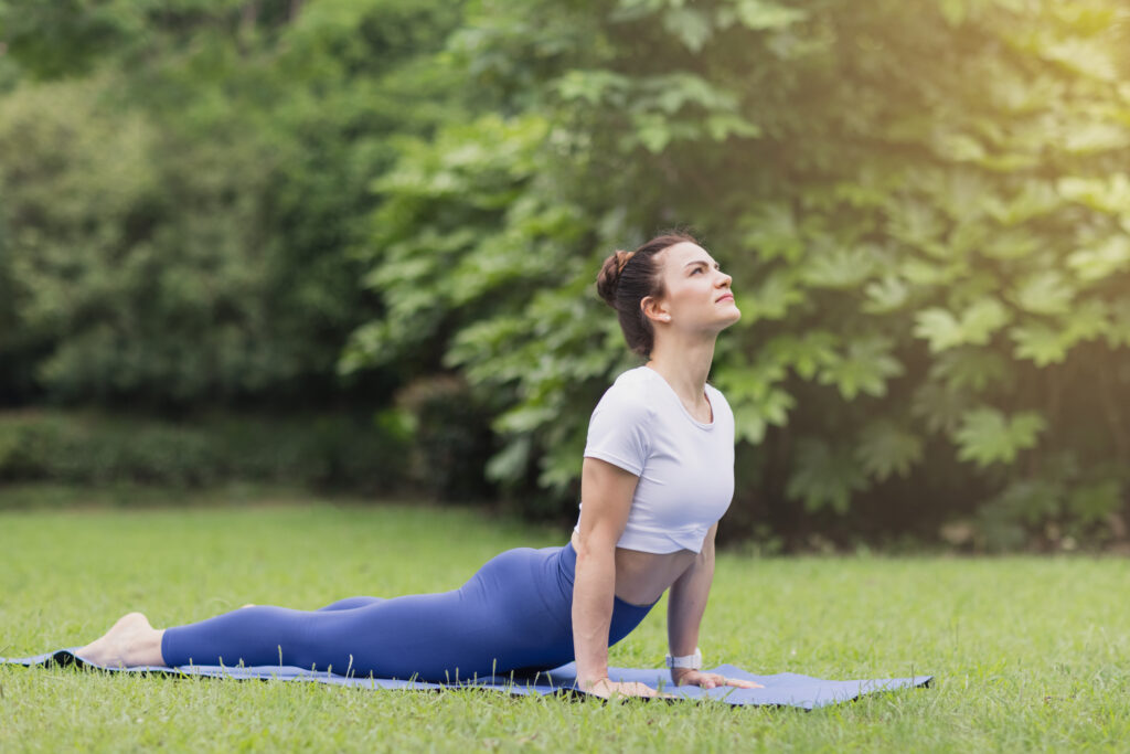 Woman on a Yoga mat stretching in a park