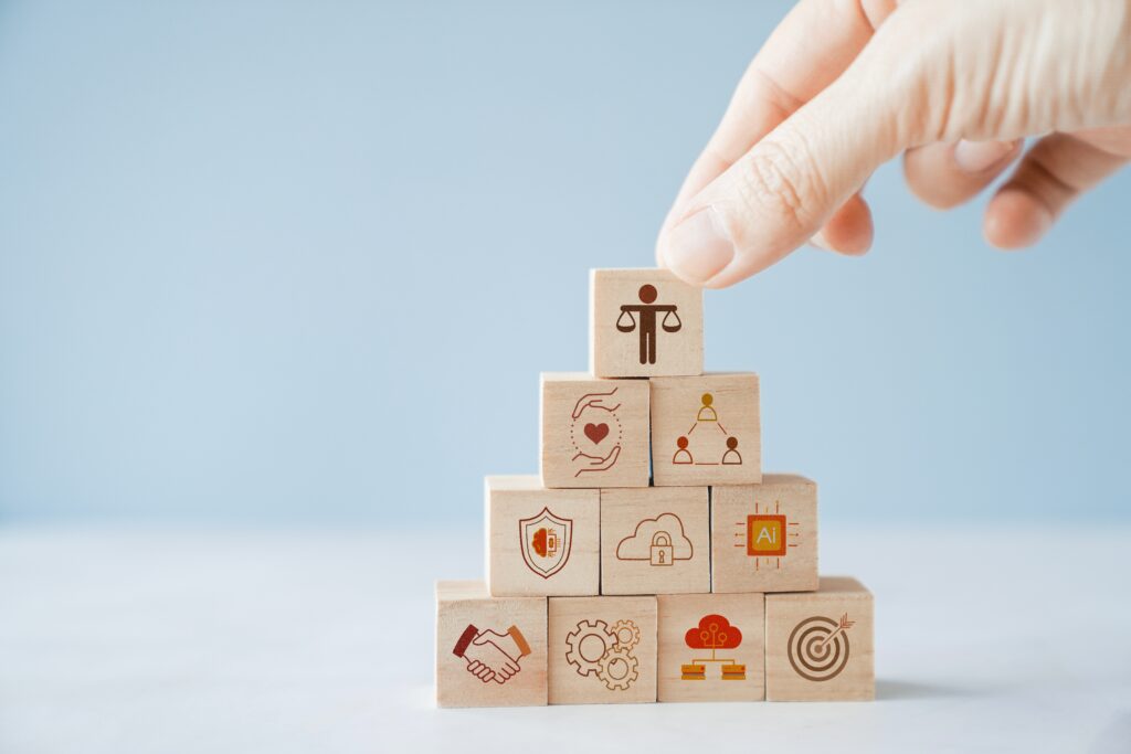 A hand places a wooden block in place symbolizing elements of building a legacy